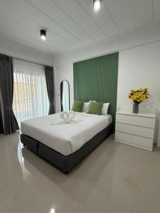 a bedroom with a large bed with a flower on it at I am Daily Mansion in Ban Phan Sadet Nai