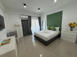 a bedroom with a bed and a television in it at I am Daily Mansion in Ban Phan Sadet Nai +10 photos