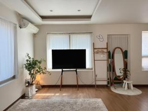 a living room with a flat screen tv and a window at Gapyeong Sol Stay Spa Pension in Gapyeong