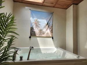 a bathroom with a bath tub with a picture of palm trees at Gapyeong Sol Stay Spa Pension in Gapyeong