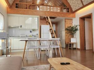 a kitchen with a table and chairs and a loft at Gapyeong Sol Stay Spa Pension in Gapyeong