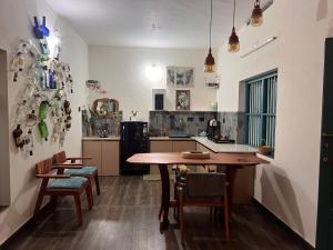 a kitchen with a wooden table and chairs at Kabani By Kallar in Trivandrum