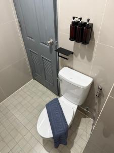 a bathroom with a toilet with a blue towel on it at I am Daily Mansion in Ban Phan Sadet Nai