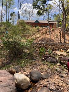 a house on a hill with a stone wall and a creek at Kabani By Kallar in Trivandrum