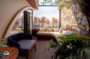 an outdoor patio with a couch and a stone wall at Champton Nha Trang Hotel in Nha Trang
