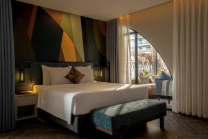 a bedroom with a large bed with a colorful wall at Champton Nha Trang Hotel in Nha Trang