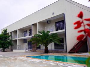 a building with a swimming pool in front of it at Mevis Boutique Hotel in Bulawayo