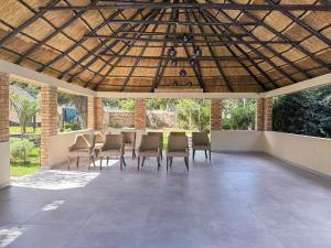 a patio with chairs and a table under a wooden ceiling at Mevis Boutique Hotel in Bulawayo