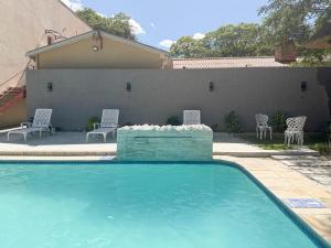 a swimming pool with chairs and a retaining wall at Mevis Boutique Hotel in Bulawayo