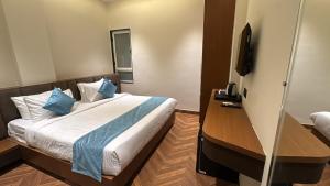 a hotel room with a bed and a television at Hotel Golden Bird in Dabok +45 photos