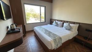 a bedroom with a large bed with a window at Hotel Golden Bird in Dabok