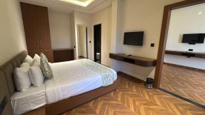 a hotel room with a bed and a television at Hotel Golden Bird in Dabok
