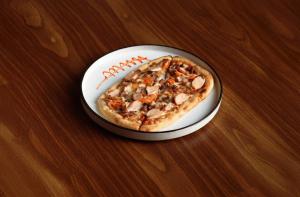 a small pizza in a box on a table at asar Capoors Hotel Hazratganj by Orion Hotels in Lucknow