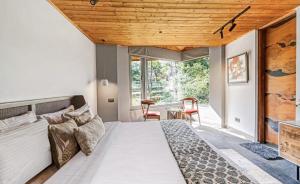 a bedroom with a large bed with a wooden ceiling at SaffronStays The Hill Abode in Kasauli