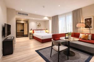 a hotel room with a bed and a couch at VCity Suites at The Teacher in Glasgow