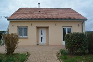 a small house with a white door and a brick driveway at Charmes à Changey in Changey
