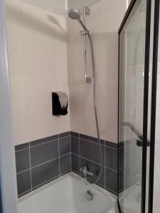 a bathroom with a shower with a bath tub at Hôtel Saint Daniel in Nantes