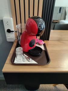 a red mixer sitting on a tray on a table at Hôtel Saint Daniel in Nantes