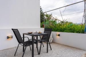 a small black table and chairs on a balcony at Linea Nest Studio Near the Beach in Pissidhón