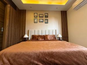 a bedroom with a large bed with two lamps at Mahadev Hotel in Zirakpur