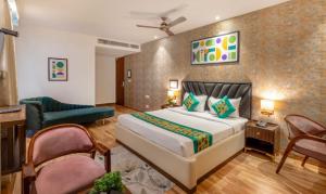 a bedroom with a bed and a chair and a couch at Mahadev Hotel in Zirakpur