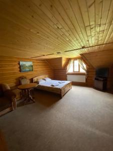 a large room with a bed and a table in it at Три підкови in Mykulychyn