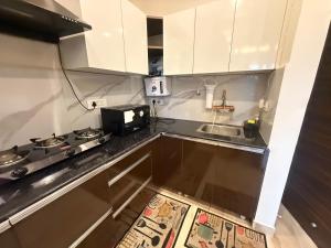 a small kitchen with a sink and a microwave at Mahadev Hotel in Zirakpur