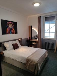 a bedroom with a bed and a window and a desk at Hôtel Saint Daniel in Nantes +17 photos