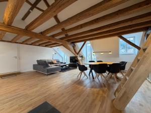 a living room with wooden ceilings and a table and chairs at Schloss Espasingen Apartment 4 in Stockach +16 photos