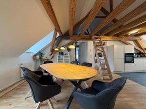 a kitchen and dining room with a wooden table and chairs at Schloss Espasingen Apartment 4 in Stockach