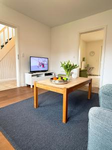 a living room with a coffee table and a tv at Haus Charlotte mit Meerblick in Fehmarn