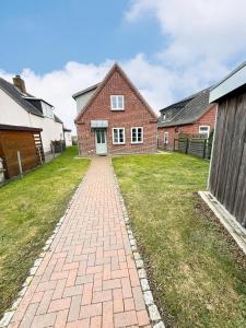 a brick driveway in front of a house at Haus Charlotte mit Meerblick in Fehmarn