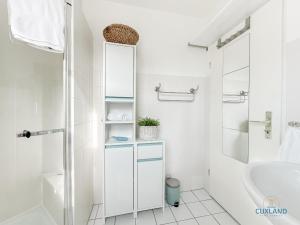 a white bathroom with a sink and a mirror at Marina Liebe in Cuxhaven +17 photos