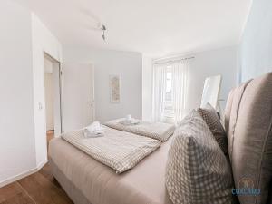 a white room with two beds and a window at Marina Liebe in Cuxhaven