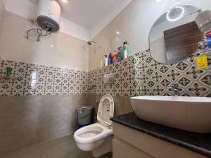 a bathroom with a sink and a toilet and a mirror at Mahadev Hotel in Zirakpur