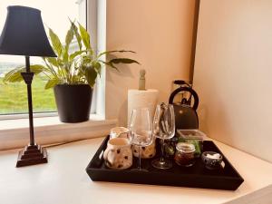 a tray with glasses and a lamp on a table at Follies Garden Studio in Dungarvan +10 photos