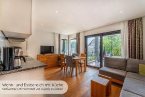 a kitchen and living room with a couch and a table at INVITA Natur-Chalets - Familienurlaub im Schwarzwald in Bad Dürrheim