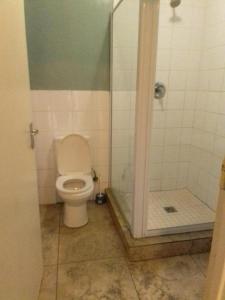a bathroom with a toilet and a shower at Lodge & Backpackers at Star Legend Parow in Parow