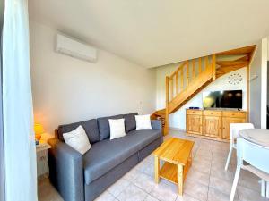 a living room with a couch and a table at La salamandre bleue : 4 pers piscine à Calvisson in Calvisson