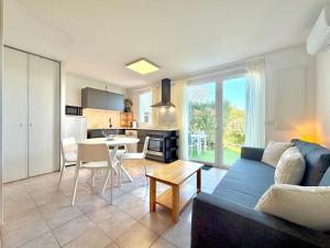 a living room with a blue couch and a kitchen at La salamandre bleue : 4 pers piscine à Calvisson in Calvisson