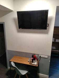 a room with a table and a television on a wall at Hôtel Saint Daniel in Nantes