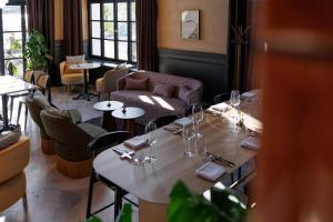 a dining room with tables and chairs and windows at Jadran Heritage Hotel, Valamar Collection in Poreč