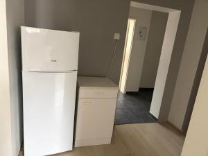 a white refrigerator in a room with a hallway at Ferienwohnung in Witten
