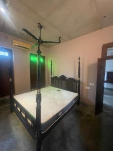 a bed in a room with a ceiling fan at Weaver Bird Residencies in Hewagama