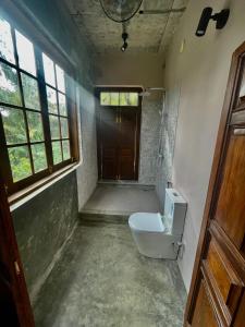 a bathroom with a toilet and a door at Weaver Bird Residencies in Hewagama +6 photos
