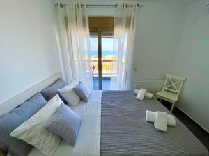a bedroom with a bed with pillows and a balcony at Nautica Villa in Hanioti +47 photos