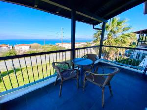 a balcony with a table and chairs and the ocean at Nautica Villa in Hanioti