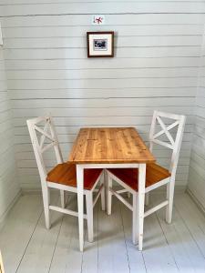 a wooden table and two chairs in a room at Vuohensaari, Rantatalo 4 in Salo