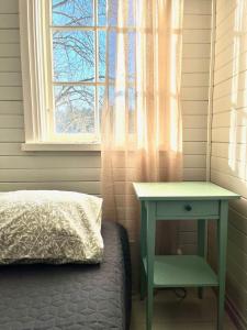 a bed and a table next to a window at Vuohensaari, Rantatalo 4 in Salo +3 photos
