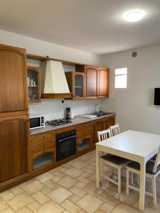 a kitchen with wooden cabinets and a white table at Regina House Cattolica in Cattolica